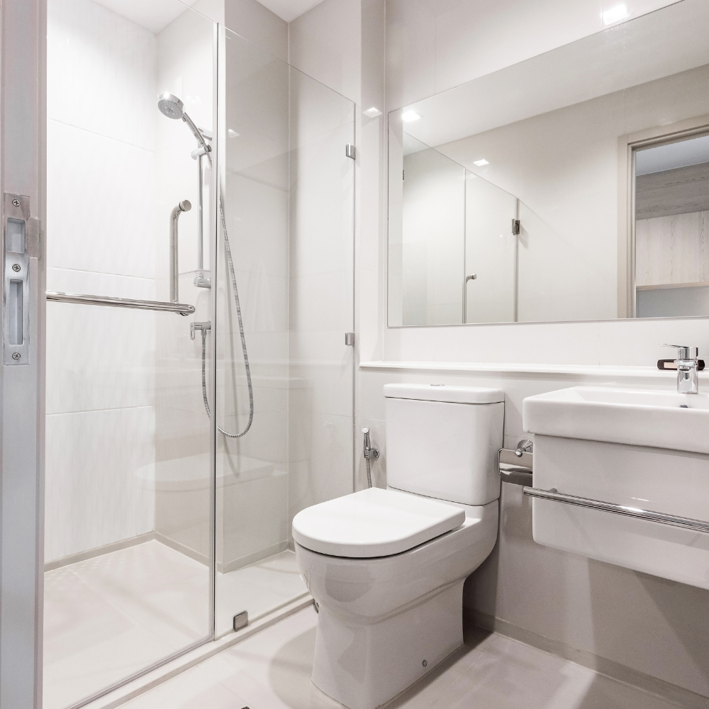 Compact bathroom with a walk-in glass shower, wall-hung basin and large mirror